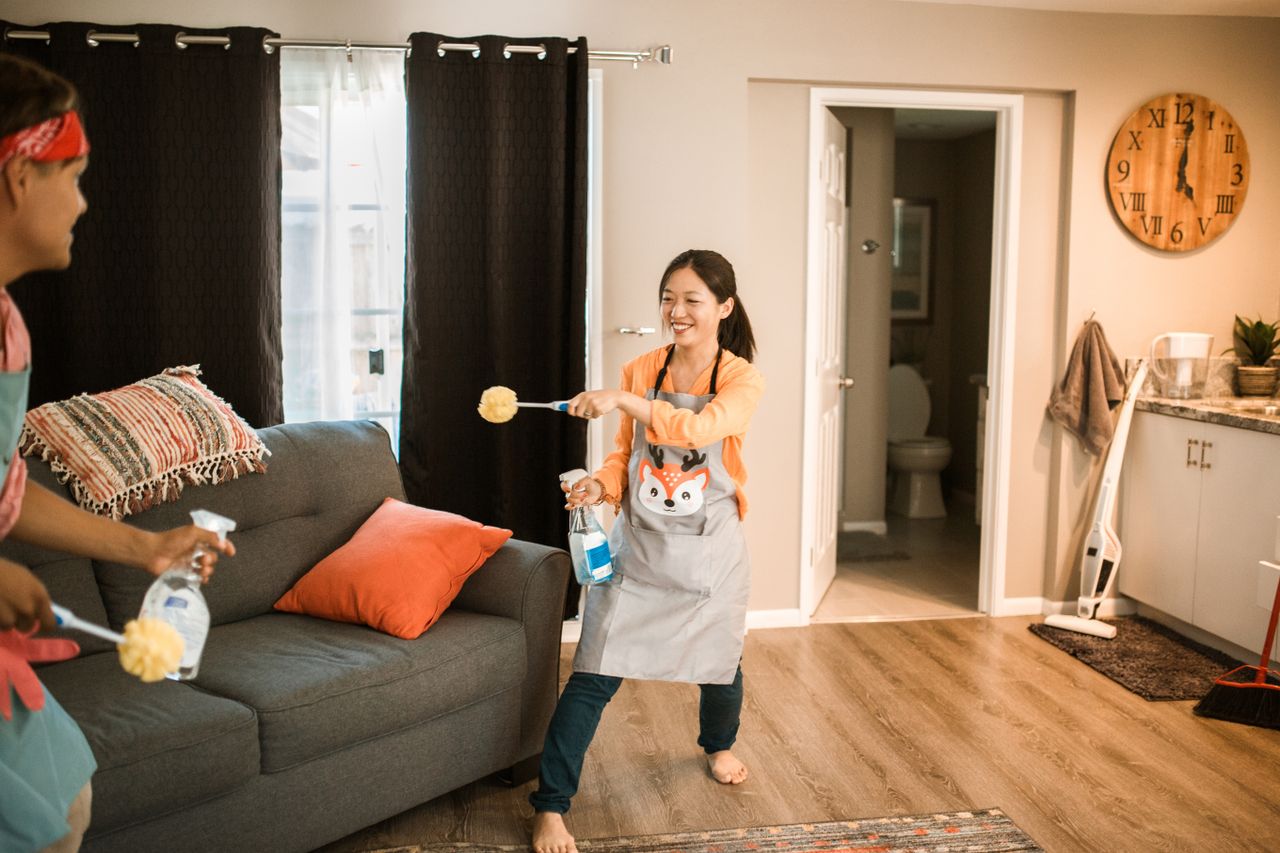 about-us-02 A cheerful couple engages in a playful cleaning session in their home.